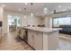 Kitchen island featuring stainless steel sink with seating and a view into the dining and living areas at 10049 Cardinal Knoll Ave, Las Vegas, NV 89143