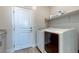 Clean and functional laundry room with modern washer and dryer, a shelf, and white door at 10049 Cardinal Knoll Ave, Las Vegas, NV 89143