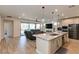 Open-concept living space with a kitchen island, stainless steel appliances, and seamless flow to the living room at 10049 Cardinal Knoll Ave, Las Vegas, NV 89143