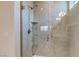 Tiled shower featuring glass enclosure, a rainfall showerhead, and built-in shelves at 10049 Cardinal Knoll Ave, Las Vegas, NV 89143