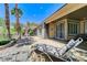 Spacious covered back patio with lounge chair and desert landscaping at 10237 Andante Ct, Las Vegas, NV 89135