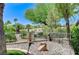Backyard landscaping featuring rocks, tiki statues, and mature trees at 10237 Andante Ct, Las Vegas, NV 89135