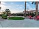 Private backyard featuring a fire pit, artificial turf, palm trees, and ample seating, perfect for outdoor relaxation and entertaining at 10801 Clarion Ln, Las Vegas, NV 89134