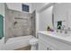 Well-lit bathroom with tub, shower, tiled niche, and a sleek white vanity with a modern faucet at 10801 Clarion Ln, Las Vegas, NV 89134