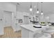 Bright kitchen boasts a waterfall island with seating and modern pendant lighting at 10801 Clarion Ln, Las Vegas, NV 89134