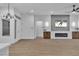 Spacious living room featuring a fireplace, tv, modern light fixture and open layout for entertaining at 10801 Clarion Ln, Las Vegas, NV 89134