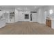 Bright and airy open-concept living space with wood floors, stylish lighting, and kitchen view at 10801 Clarion Ln, Las Vegas, NV 89134