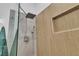 Detail of the bathroom shower with wood-look tile surround and modern fixtures at 10801 Clarion Ln, Las Vegas, NV 89134
