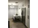 Modern kitchen with stainless steel refrigerator, dining area, and white cabinetry at 111 E Van Wagenen St, Henderson, NV 89015