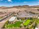 Aerial view of a home featuring a large backyard with a pool, putting green, and covered patio at 11238 Rebel Dome Ct, Las Vegas, NV 89141