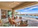 A covered back patio with a wood table sits next to the pool and offers scenic views at 11238 Rebel Dome Ct, Las Vegas, NV 89141