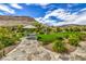 Lush backyard featuring a stone path, manicured lawn, and mountain views at 11238 Rebel Dome Ct, Las Vegas, NV 89141