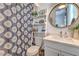 Stylish bathroom features a shower with patterned curtain and modern vanity with round mirror at 11238 Rebel Dome Ct, Las Vegas, NV 89141