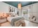 Stylish bedroom with a modern rustic bed, a statement light fixture, and a cozy hanging chair, creating a relaxing retreat at 11238 Rebel Dome Ct, Las Vegas, NV 89141