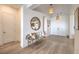 A welcoming foyer with wood floors is decorated with a round mirror, bench, and pendant lights at 11238 Rebel Dome Ct, Las Vegas, NV 89141