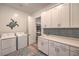Spacious laundry room with white cabinetry, sink, and washer/dryer at 11238 Rebel Dome Ct, Las Vegas, NV 89141