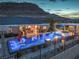 A gorgeous pool with fire pits and lounge chairs surrounded by a black fence sits in front of a hillside at 11238 Rebel Dome Ct, Las Vegas, NV 89141