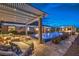 Inviting outdoor pool area with covered lounge, outdoor seating, lush greenery, and integrated spa features at 11238 Rebel Dome Ct, Las Vegas, NV 89141