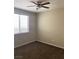 A room with a ceiling fan and a window, with neutral walls and brown carpeting at 12243 Pacific Cruise Ave, Las Vegas, NV 89138
