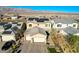 Aerial view of a home with solar panels, three-car garage, brick driveway, and desert landscaping at 1610 Dire Wolf Avenue, North Las Vegas, NV 89084