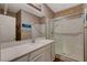 Well-lit bathroom with a white vanity, large mirror, and enclosed shower with glass doors at 1610 Dire Wolf Avenue, North Las Vegas, NV 89084