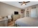 Inviting bedroom with light walls, wood-look floors, ceiling fan, and a functional desk area with a chair at 1610 Dire Wolf Avenue, North Las Vegas, NV 89084