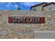Stone Creek community sign on a stone wall with colorful stones, a welcoming entrance to the neighborhood at 1610 Dire Wolf Avenue, North Las Vegas, NV 89084