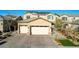 Two-story home with a three-car garage, brick driveway, desert landscaping, and a well-maintained front yard at 1610 Dire Wolf Avenue, North Las Vegas, NV 89084
