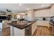 Open-concept kitchen with granite island and stainless steel appliances flows into living and dining areas at 1610 Dire Wolf Avenue, North Las Vegas, NV 89084
