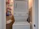 Conveniently located stacked washer and dryer with shelving for storage in laundry closet at 1610 Dire Wolf Avenue, North Las Vegas, NV 89084