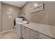 Laundry room showcasing a washer, dryer, countertops, white cabinetry, and decor at 1610 Dire Wolf Avenue, North Las Vegas, NV 89084