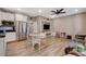 Open floor plan showcasing kitchen with stainless appliances, table with chairs, and entertainment center in living room at 1610 Dire Wolf Avenue, North Las Vegas, NV 89084