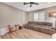 Cozy living room with wood flooring, neutral walls, ceiling fan, and large sectional sofa at 1610 Dire Wolf Avenue, North Las Vegas, NV 89084