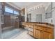 Bright bathroom featuring wood cabinets, granite countertops, and glass shower with tile walls at 1904 Bellview St, Las Vegas, NV 89134
