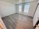 Well-lit bedroom featuring wood-look flooring, two windows, and neutral walls at 2064 Mesquite Ln # 102, Laughlin, NV 89029