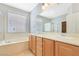 Bright bathroom featuring a double vanity, soaking tub, and separate shower with tile surround at 2183 Waterton Rivers Dr, Henderson, NV 89044