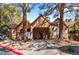 Clubhouse with a terra cotta-colored facade, mature trees, and a sidewalk leading to the entrance at 2200 S Fort Apache Rd # 2015, Las Vegas, NV 89117