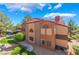 Two-story condo with stucco exterior, red tile roof, manicured landscaping, and a gravel ground covering at 2200 S Fort Apache Rd # 2015, Las Vegas, NV 89117