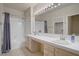 Bright bathroom showcasing a double sink vanity, large mirror with Hollywood lighting, and shower-tub combo at 2325 Windmill Pkwy # 321, Henderson, NV 89074