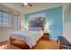 Bright bedroom with blue accent wall, hardwood floors, and ample natural light at 2325 Windmill Pkwy # 321, Henderson, NV 89074