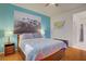 Bright bedroom with blue accent wall, hardwood floors, and an ensuite bathroom at 2325 Windmill Pkwy # 321, Henderson, NV 89074