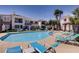 Inviting community pool surrounded by lounge chairs, umbrellas and lush landscaping at 2325 Windmill Pkwy # 321, Henderson, NV 89074
