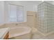 Bright bathroom featuring soaking tub with glass block window, and bright natural light at 2410 Sunburst View St, Henderson, NV 89052