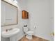 Powder room with a pedestal sink, decorative mirror, and modern fixtures at 2410 Sunburst View St, Henderson, NV 89052
