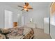Bright bedroom featuring a ceiling fan, neutral carpet, and ensuite bathroom and dresser at 2410 Sunburst View St, Henderson, NV 89052