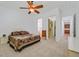Bright bedroom featuring a ceiling fan, neutral carpet, and ensuite bathroom and walk-in closet at 2410 Sunburst View St, Henderson, NV 89052