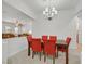 Dining area with red upholstered chairs and stylish chandelier, adjacent to entry and living space at 2410 Sunburst View St, Henderson, NV 89052