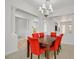 Dining area featuring a stylish chandelier, red chairs, and open access to other living spaces at 2410 Sunburst View St, Henderson, NV 89052