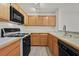 This kitchen has wood cabinets, black appliances, and countertops at 2633 S Durango Dr # 204, Las Vegas, NV 89117