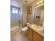 Well-lit bathroom featuring a shower with glass door, granite countertop, and wood-finish cabinet at 2694 Rimpacific Cir, Las Vegas, NV 89146
